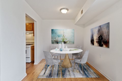 A dining room with a white table and chairs.