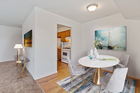 A dining room with a round table and chairs.