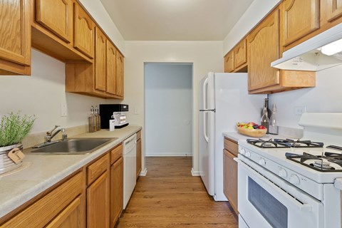 A kitchen with wooden cabinets and a white refrigerator.