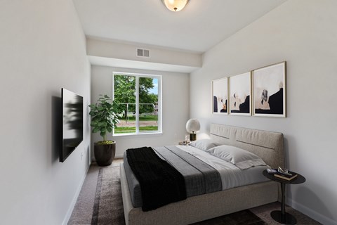 A bedroom with a large bed and a flat screen TV mounted on the wall.