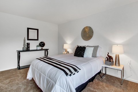 A bedroom with a large bed and a mirror on the wall.