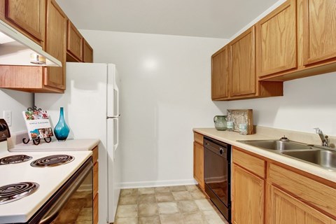 A kitchen with wooden cabinets and a white stove top.