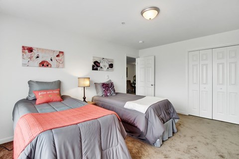 A bedroom with two beds and a painting on the wall.