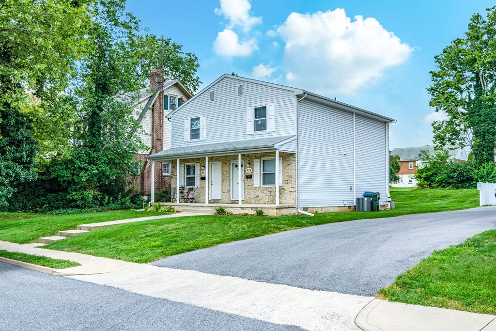 A house with a grey facade is surrounded by greenery.