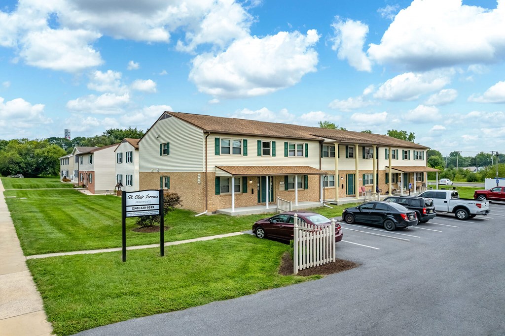 A building with a sign in front of it and cars parked in front of the building.