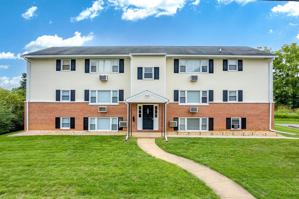 A two-story building with a brick facade and a white roof.