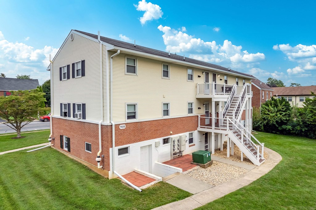 A two-story apartment building with a balcony on the second floor.