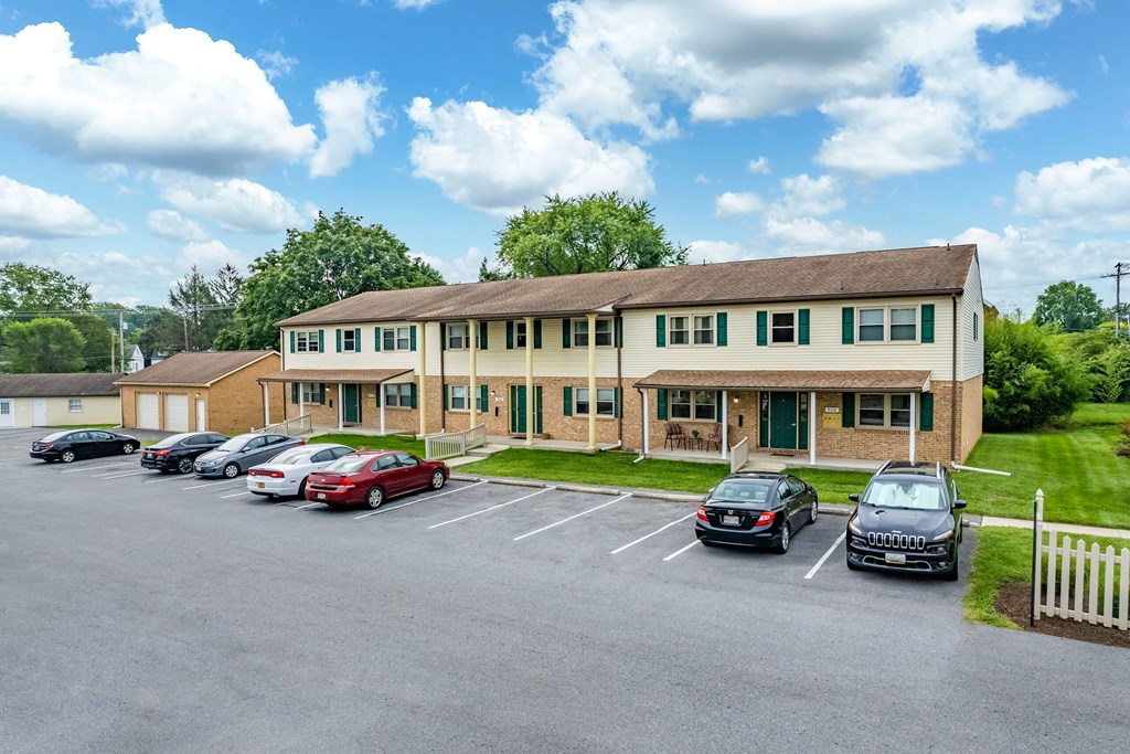 A parking lot with cars and a building in the background.
