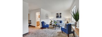 A living room with a blue chair and a white couch.
