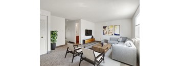 A living room with a grey couch, a wooden coffee table, and a television.