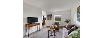 A living room with a couch, chairs, and a television.
