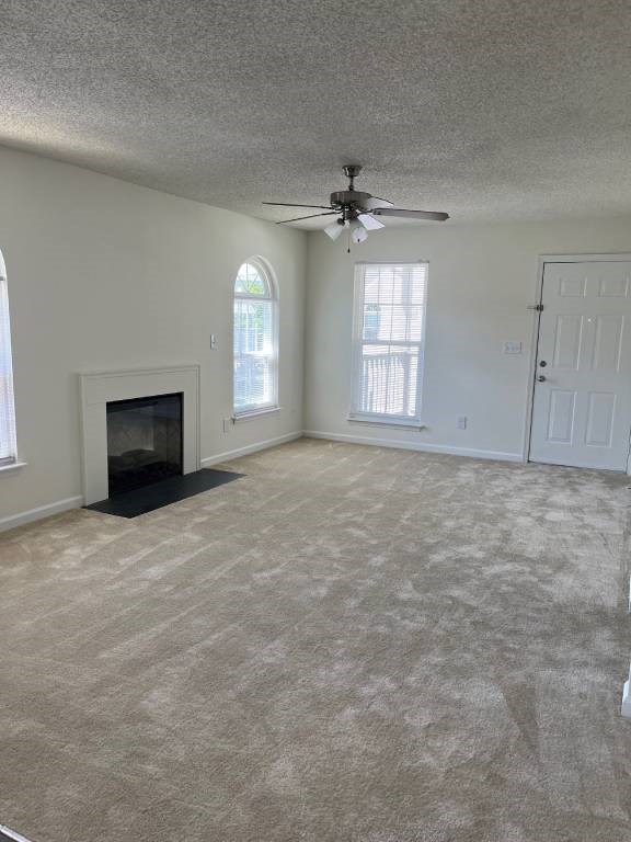 A living room with a fireplace and a ceiling fan.