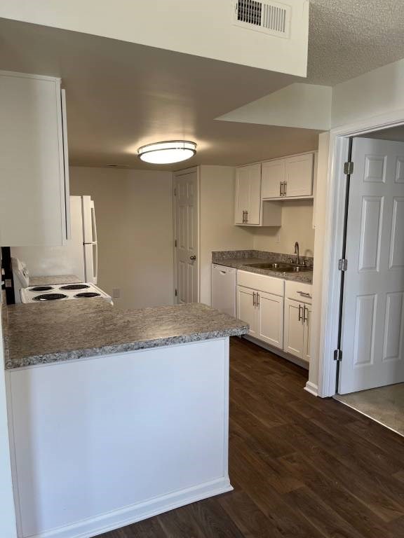 A kitchen with white cabinets and a granite countertop.
