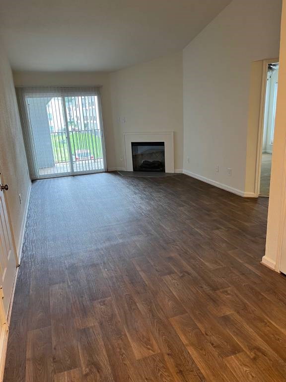 A room with wooden flooring and a fireplace.