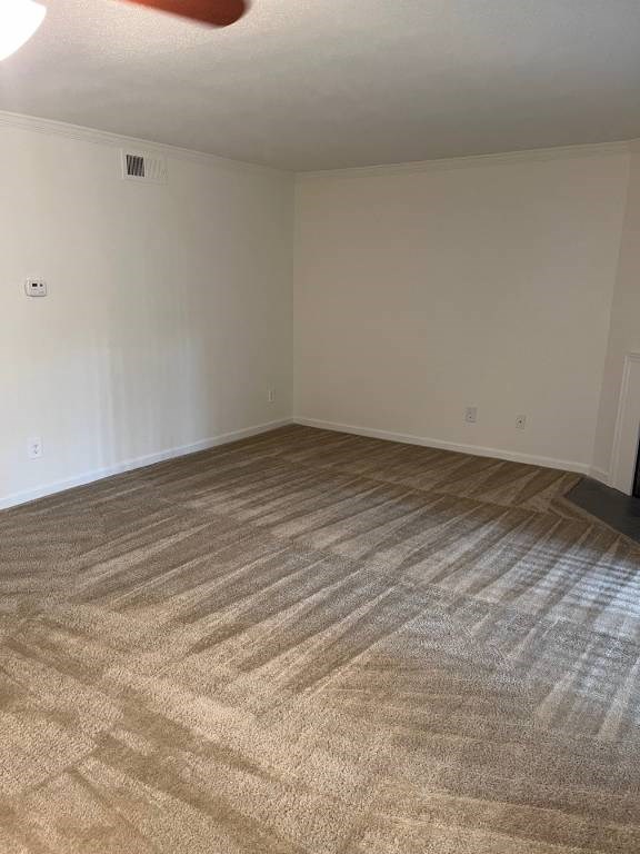 A room with a carpeted floor and a white wall.
