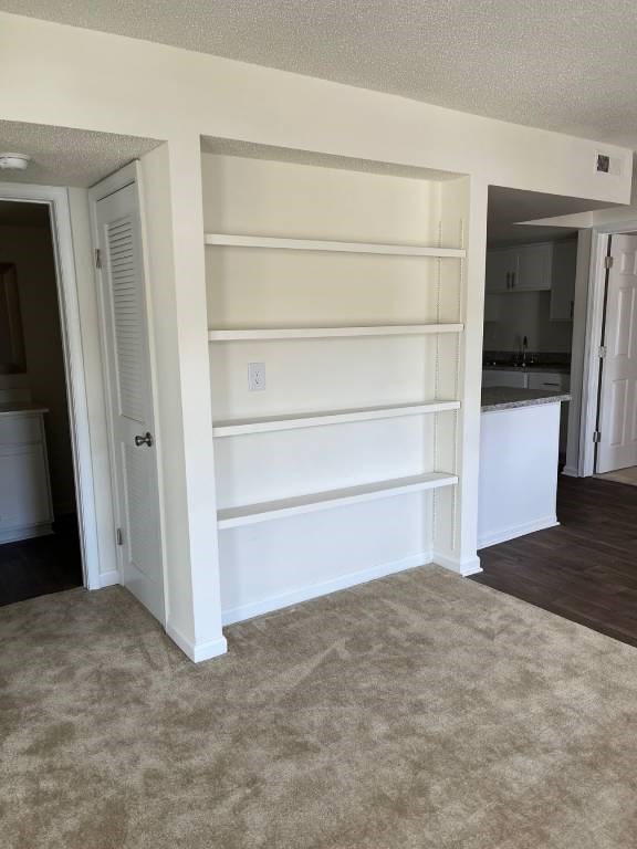 A white built-in shelf unit in a room with carpeted flooring.