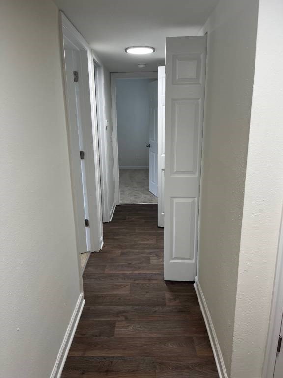 A long hallway with white doors on both sides.