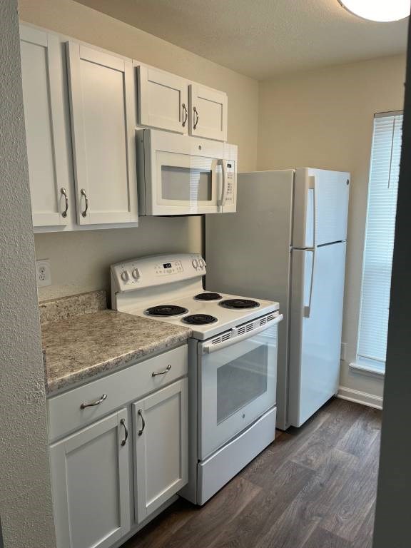 A kitchen with white appliances and cabinets.