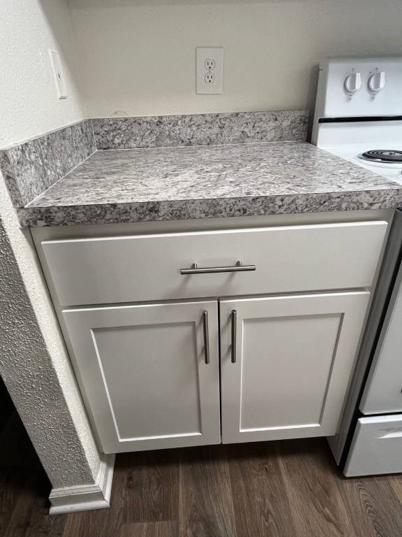 A kitchen with a granite countertop and white cabinets.