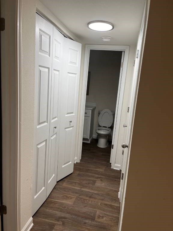 A white door is open to a bathroom with a toilet.