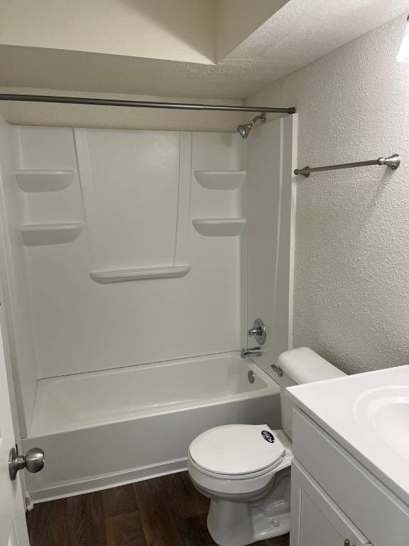 A white toilet with a white shower stall in a bathroom.