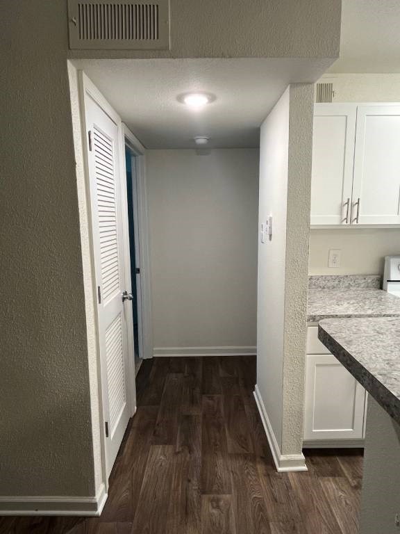A hallway with a white door and a white cabinet.