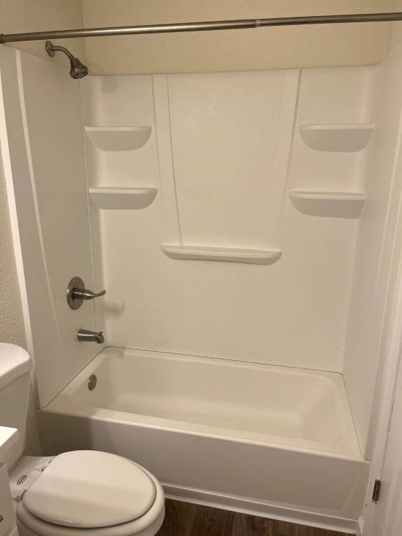 A white toilet is next to a white bathtub in a bathroom.