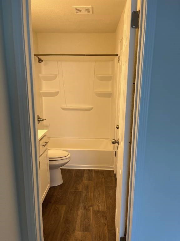 A small white toilet is in a small bathroom.