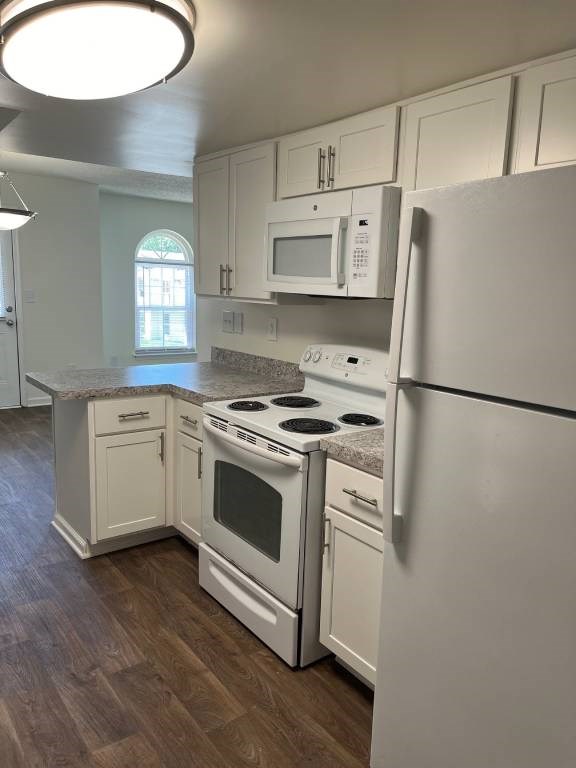 A kitchen with white appliances and cabinets.