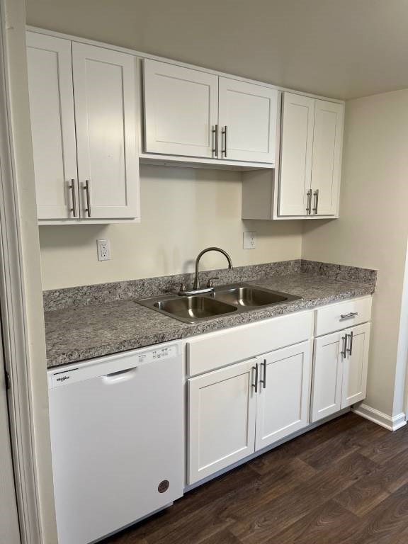 A kitchen with white cabinets and a granite countertop.