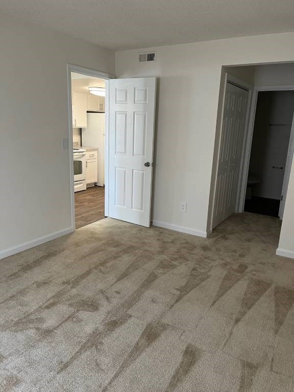 A room with a carpeted floor and a white door.