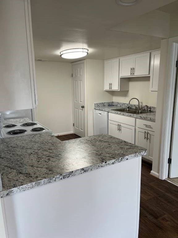 A kitchen with a granite countertop and white cabinets.