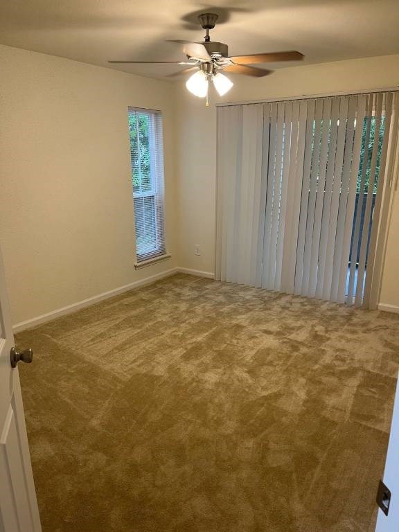 A room with a ceiling fan and a window with blinds.