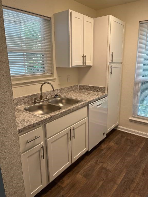 A kitchen with white cabinets and a granite countertop.