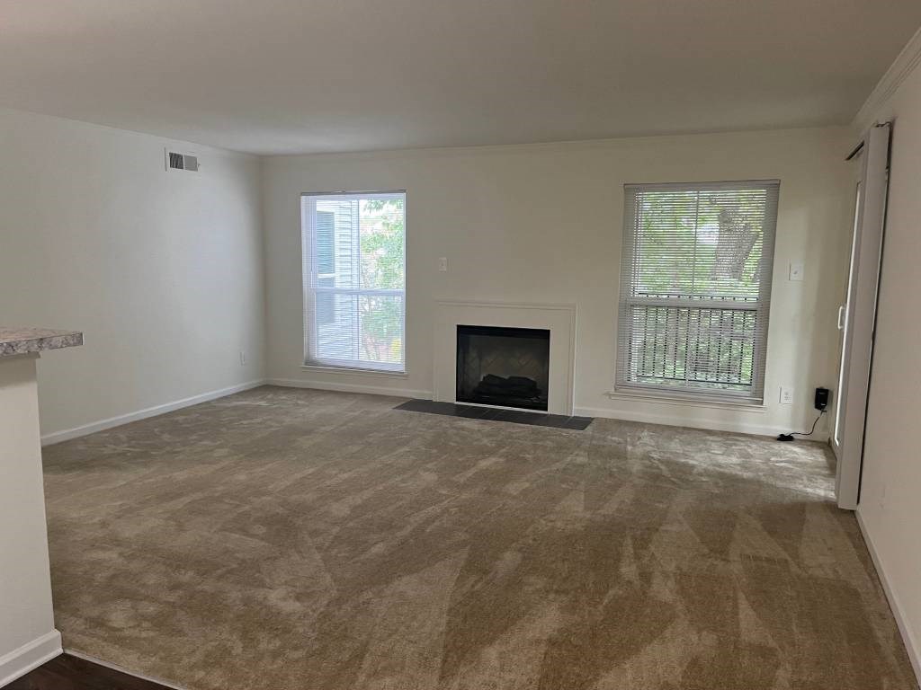 A living room with a fireplace and a window.
