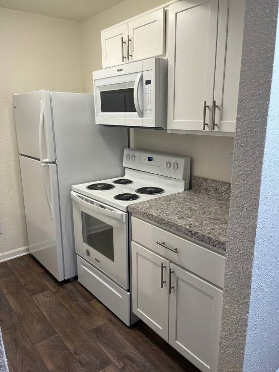 A kitchen with white appliances and cabinets.