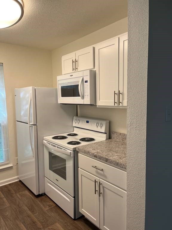 A kitchen with white appliances and cabinets.