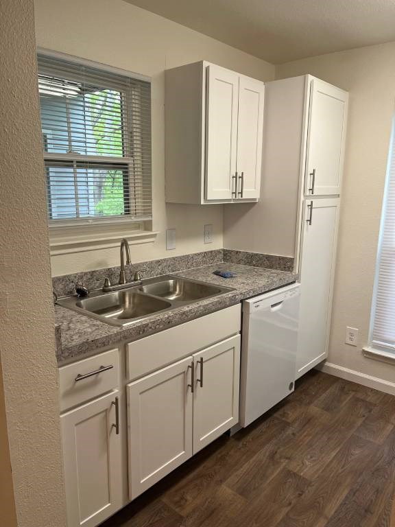 A kitchen with white cabinets and a granite countertop.