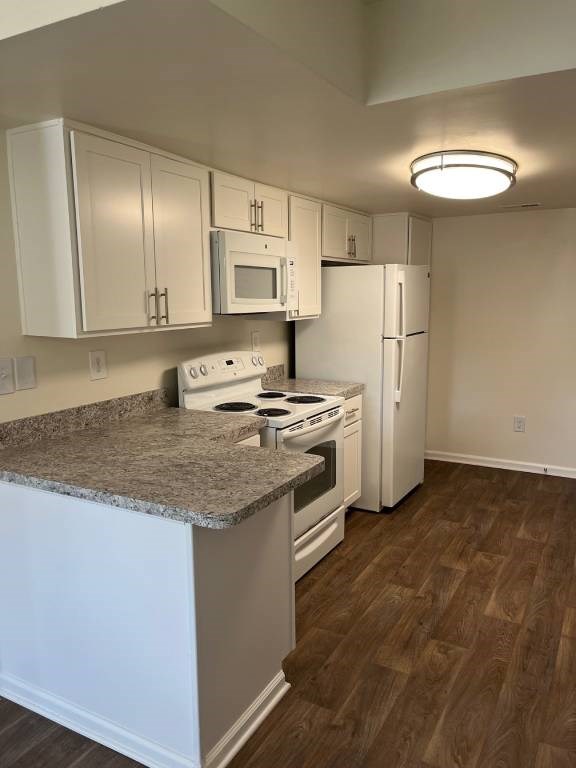 A kitchen with white cabinets and a granite countertop.