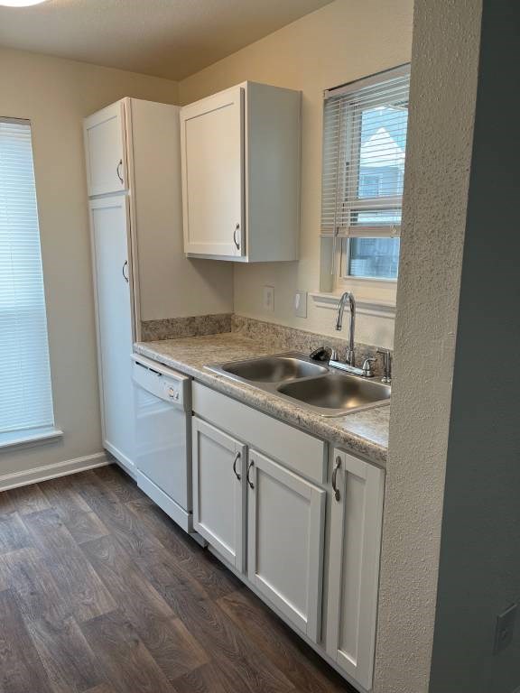 A kitchen with white cabinets and a granite countertop.