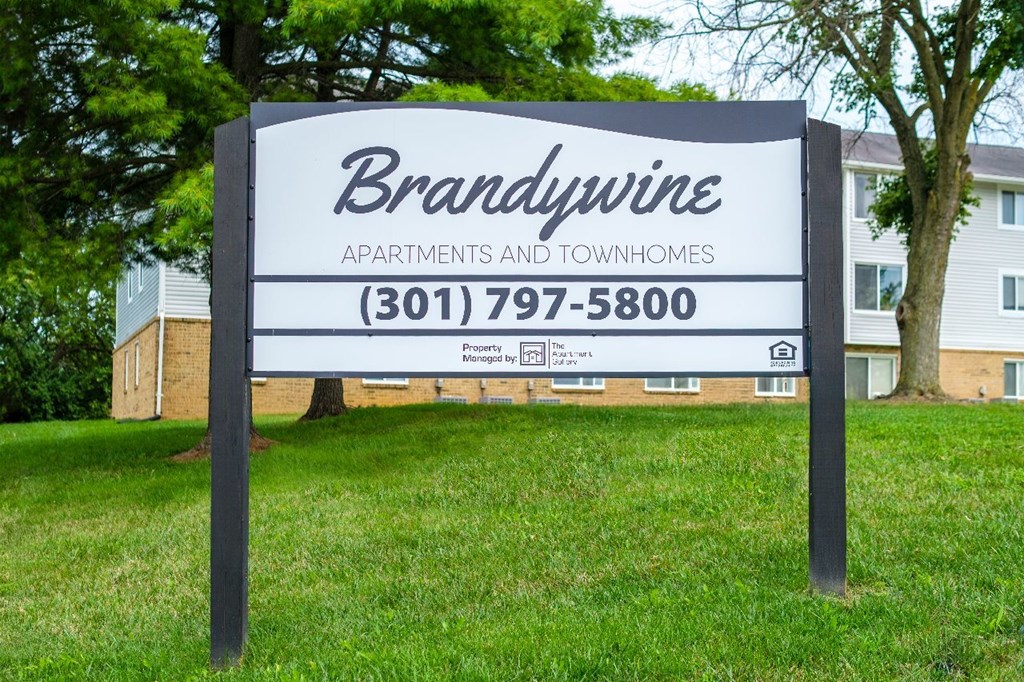 A sign for Brandywine Apartments and Townhomes stands in a grassy area.