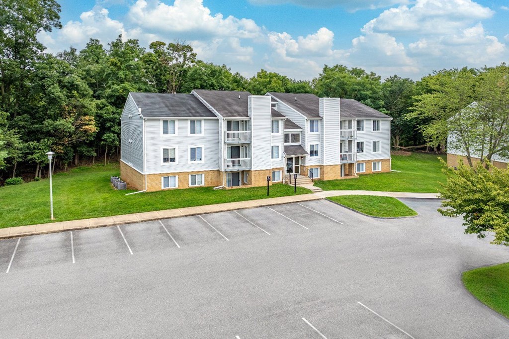A large white building with a parking lot in front.