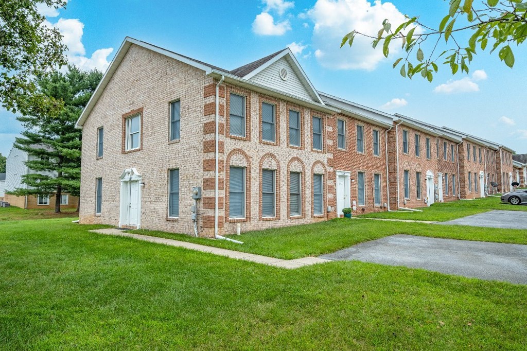 A long brick building with a white door and windows.