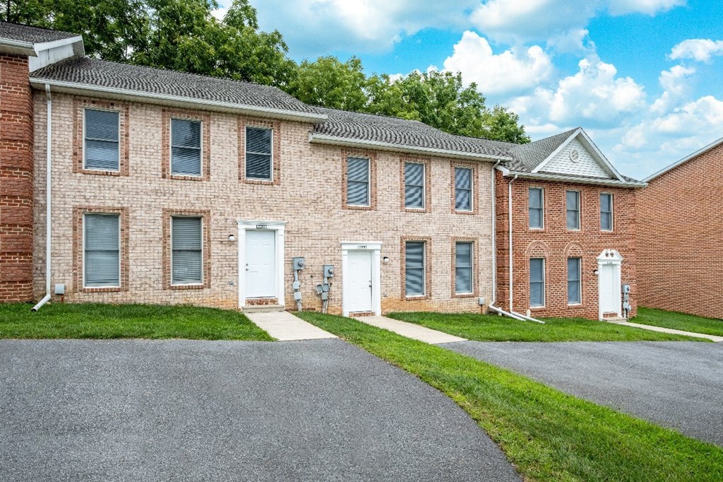 A red brick building with a white door and windows.