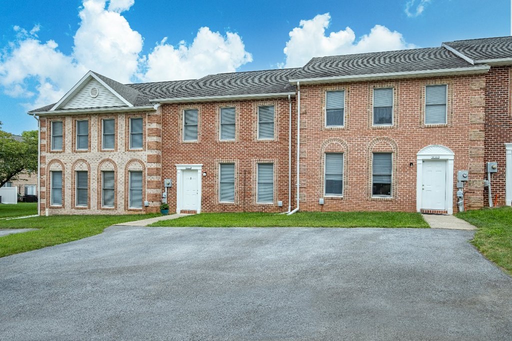 A large red brick building with a white door and windows.