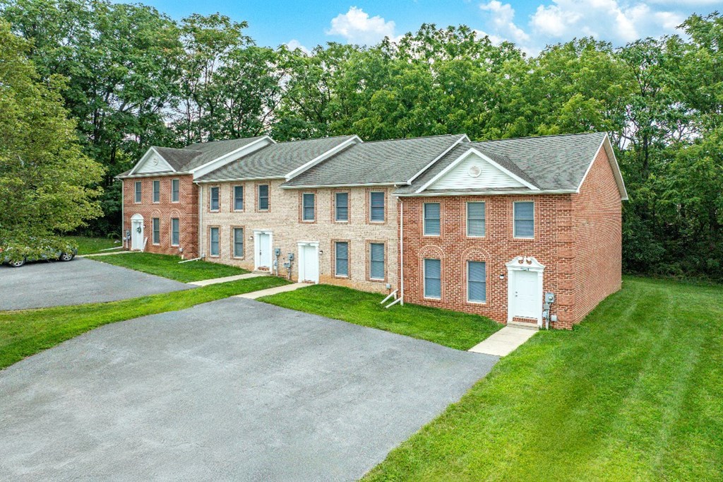 A large red brick building with a white door and windows.