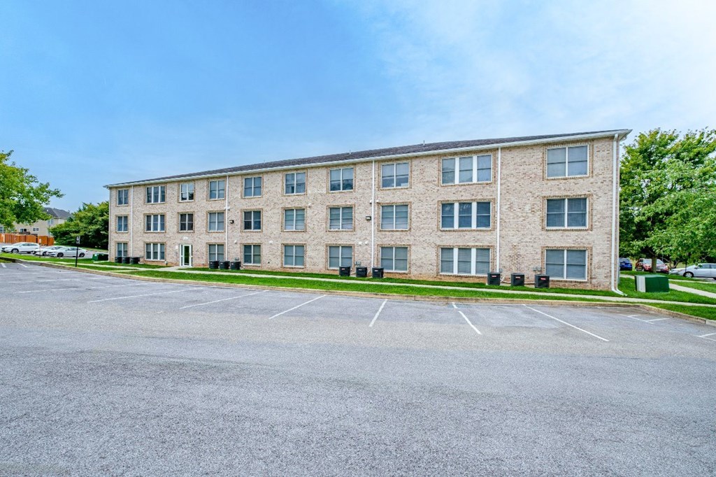 A large building with a parking lot in front.