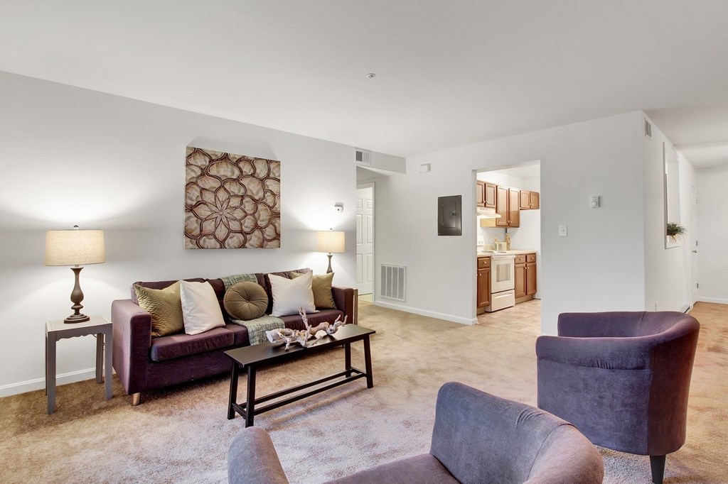 A living room with a brown couch, a grey armchair, and a coffee table.