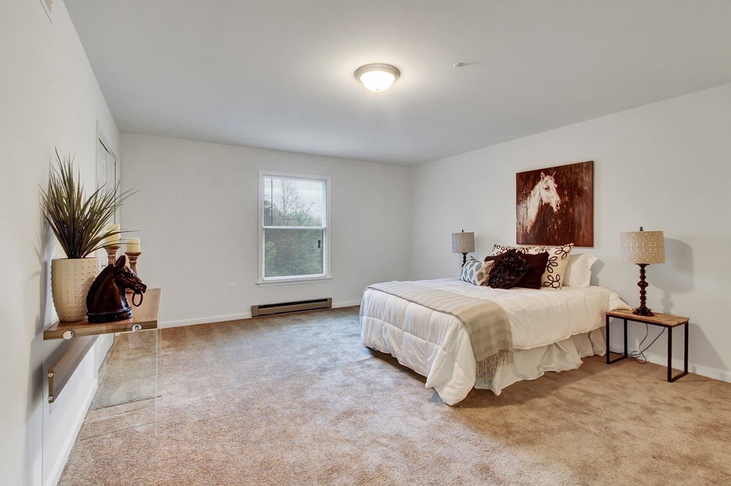 A bedroom with a large bed and a painting on the wall.