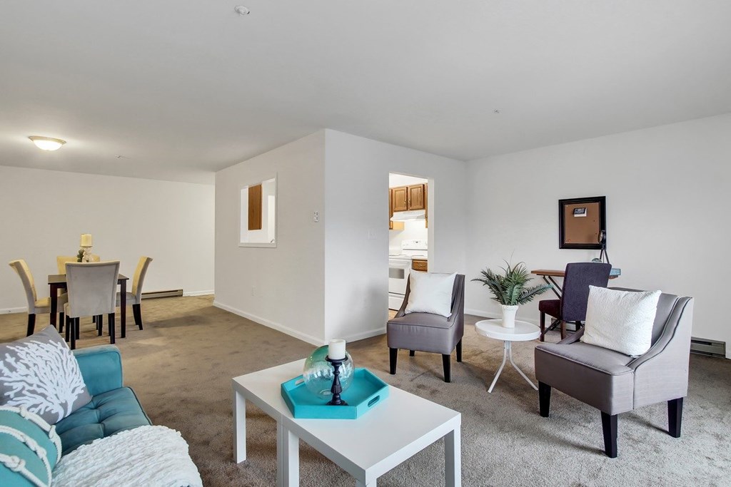 A living room with a white coffee table and grey couches.